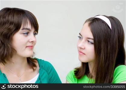 closeup portrait of two young beautiful european girls looking at each other