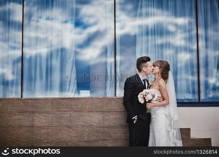 Closeup Portrait of wedding bride and groom with bouquet posing. Bridal couple, Happy Newlywed woman and man hugging. Bride and groom