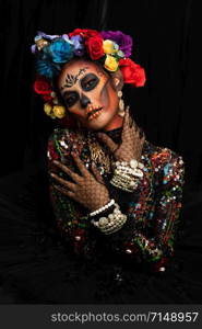 Closeup portrait of woman with a sugar skull makeup dressed with flower crown. Halloween concept