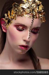 Closeup portrait of woman with creative makeup and gold foil.