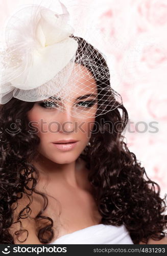 Closeup portrait of woman with gorgeous hairstyle and stunning makeup isolated on pink floral background, retro style bridal look