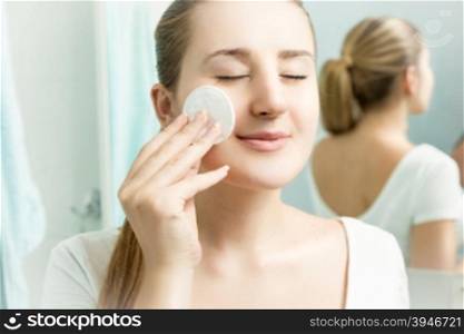 Closeup portrait of young beautiful woman cleaning skin