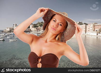 closeup portrait of young beautiful woman in brown swim suit and hat posing on white background