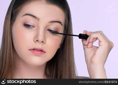 Closeup portrait of young charming applying makeup eyeshadow on her face with brush, mascara with flawless smooth skin for beauty concept.. Closeup portrait of young charming applying makeup eyeshadow with brush.