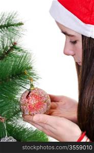 closeup portrait of young girl decorating christmas tree, holding red bauble, profile vertical shot