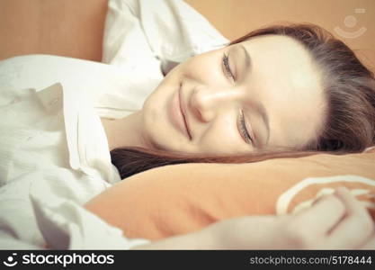 Closeup portrait of young pretty girl laying on her bed. Sleepy