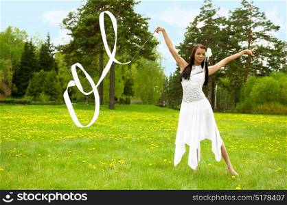 Closeup portrait of young pretty gymnast woman outdoor in summer park wearing white dress dancing and doing sports