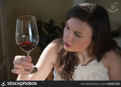 Closeup portrait of young woman drinking red wine at home