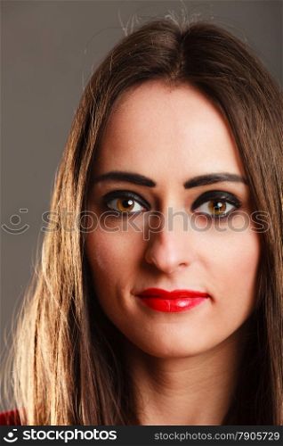 Closeup portrait smiling young woman long straight hair dark makeup red lips on gray