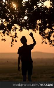 Closeup portrait young man praying hands up at sunset