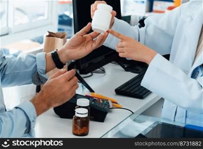 Closeup professional pharmacist advise or explain property of qualified medical product to customer in pharmacy, druggist answer to client healthcare inquiry, medical service and consultation concept.. Pharmacist advise or explain property of qualified medical product to customers.