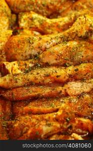 Closeup raw marinated chicken meat breast drumstick with spices and herbs as food background