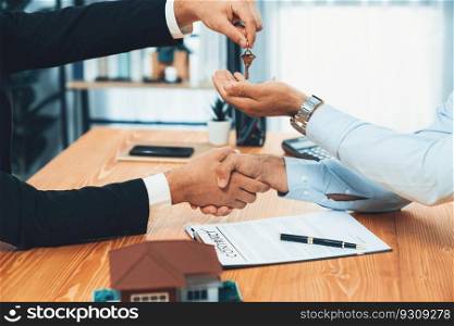 Closeup real estate broker or landlord shake hand with buyer and give a key. Client agree on house loan contract terms. Successful home purchasing deal with real estate agent in office. Fervent. Closeup real estate broker shake hand with buyer and give a key. Fervent