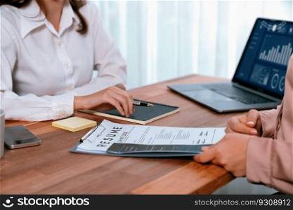 Closeup resume paper with qualifications on the desk during job interview in the office with young applicant candidates and interviewer, discussing on application of the position. Enthusiastic. Closeup resume paper with qualifications on desk during interview. Enthusiastic
