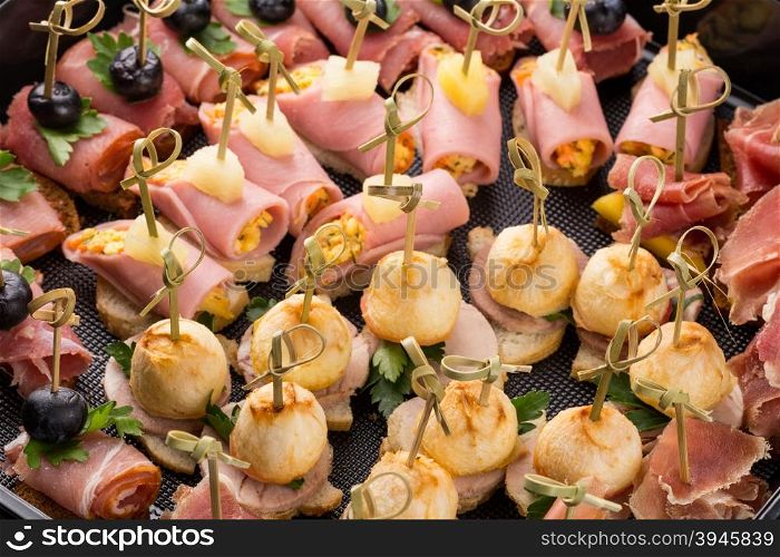 closeup set different canapes and snacks in plastic black form for mobile catering
