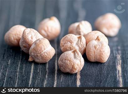 Closeup several chickpeas on a wooden table. Several dry chickpeas on wooden desk