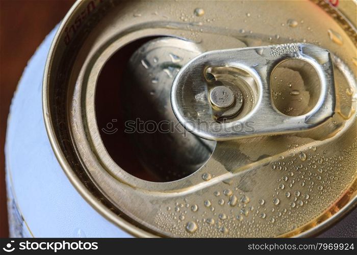 Closeup shot from the pull ring on a beverage can, opened aluminum can with water drop