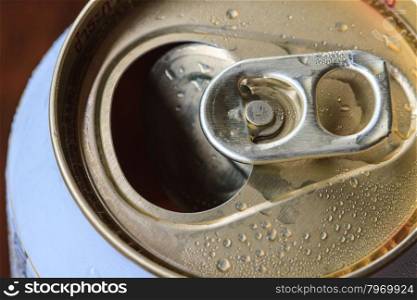 Closeup shot from the pull ring on a beverage can, opened aluminum can with water drop