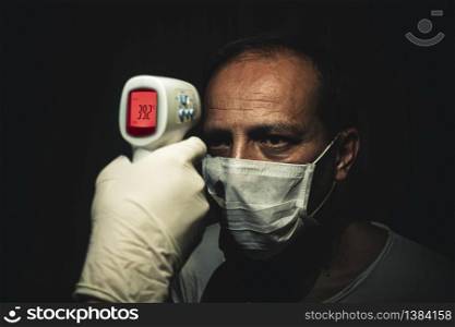 Closeup shot of a infrared thermometer measuring a senior man&rsquo;s dangerously high body temperature with fever