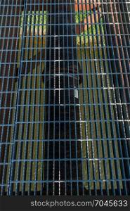 Closeup shot of a metal grid on a bridge that spans Green River in Kent, Washington.