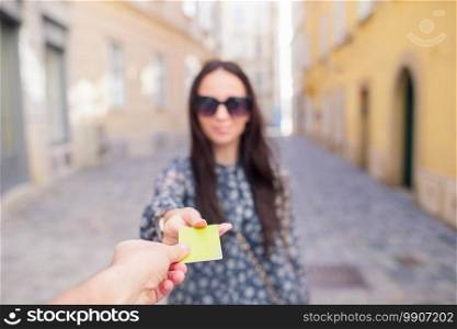 Closeup shot of a woman passing a payment credit card. Girl holding a credit card. Shallow depth of field with focus on the credit card.. Closeup shot of a woman passing a payment credit card.