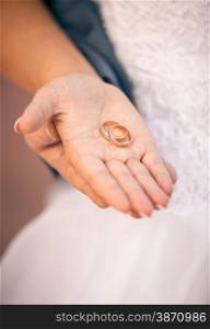 Closeup shot of beautiful bride holding wedding ring on hand