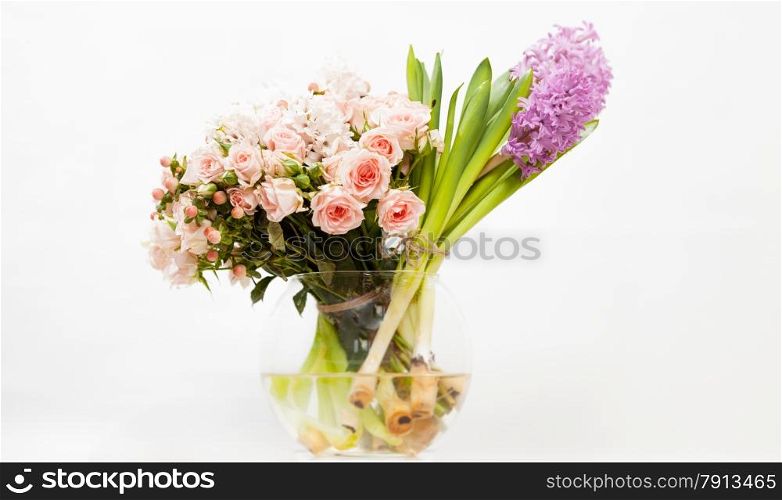 Closeup shot of colorful flowers in glass vase against white background