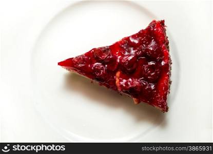 Closeup shot of delicious cherry cheesecake slice on white dish