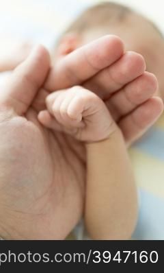 Closeup shot of father holding newborn baby hand. Image with soft focus