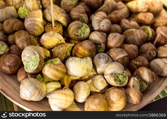 Closeup shot of fresh snails with parsley sauce lying on dish