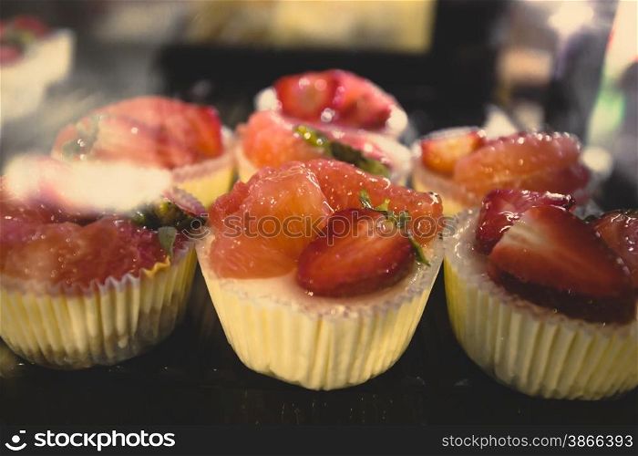Closeup shot of fresh strawberry cakes at cafe showcase