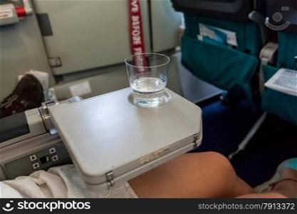 Closeup shot of glass of water standing on table in aircraft