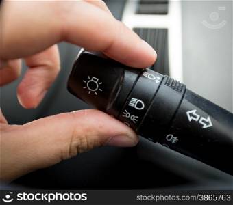 Closeup shot of man adjusting light control toggle in car