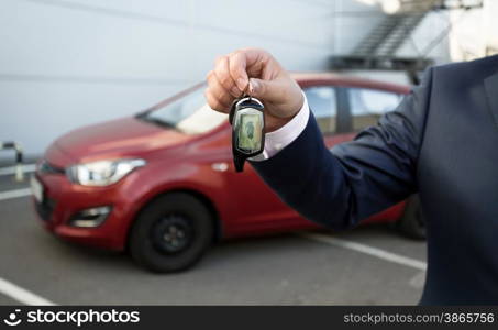 Closeup shot of man in suit showing car keys with alarm remote control