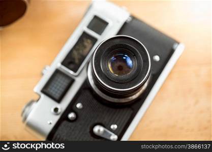 Closeup shot of old film camera lying on wooden desk