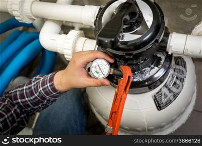 Closeup shot of plumber checking manometer on big hydraulic pump
