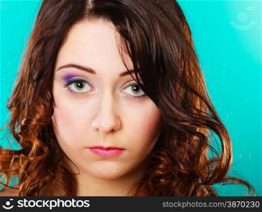 Closeup smiling woman face, girl with long brown curly hair colorful makeup portrait on green