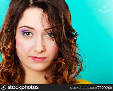 Closeup smiling woman face, girl with long brown curly hair colorful makeup portrait on green