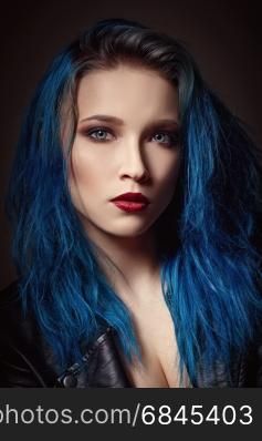 Closeup studio portrait of a beautiful young woman with blue hair