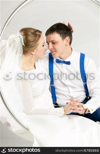 Closeup studio portrait of happy bride and groom hugging with closed eyes