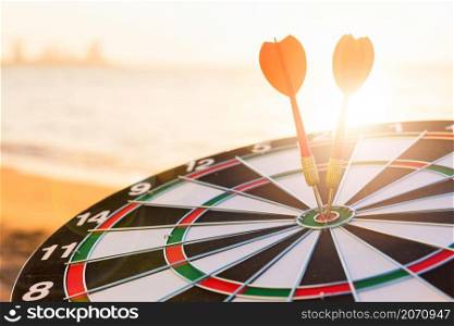 Closeup the dart arrow hit center on Bullseye(bull&rsquo;s-eye) of a dartboard is a target of challenge business, strategy marketing target, objective financial and goal a concept
