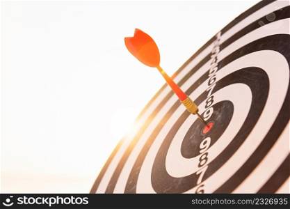 Closeup the dart arrow hit center on Bullseye(bull&rsquo;s-eye) of a dartboard is a target of challenge business, strategy marketing target, objective financial and goal a concept