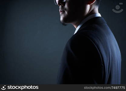 Closeup three quarter rear view of businessman with black background