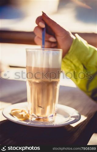 Closeup toned photo of cappuccino on wooden table at ski resort cafe