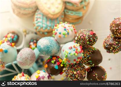 Closeup toned photo of colorful cake pops and cookies with icing