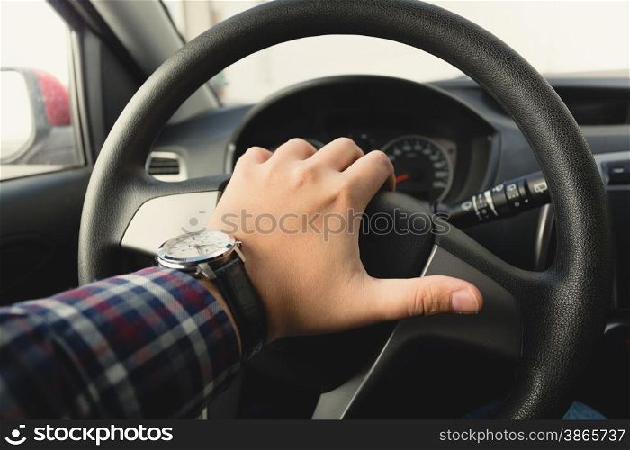 Closeup toned photo of male driver honking the horn