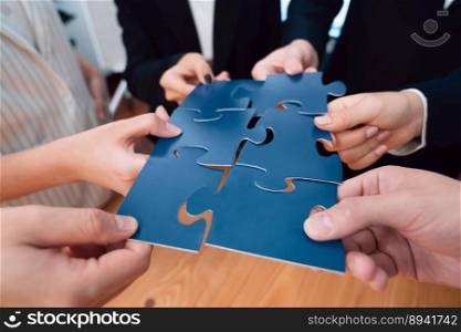 Closeup top view business team of office worker putting jigsaw puzzle together over table filled with financial report paper in workplace with manager to promote harmony concept in meeting room.. Closeup top view business people join jigsaw puzzle together in harmony office