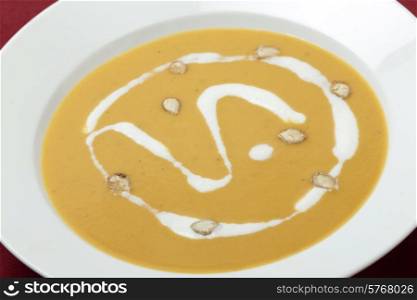 Closeup view of a plate of traditional French butternut squash soup in a bowl