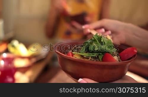 Closeup view of charming young female sitting at the table on tree house at the beach enjoying a lunch during summer&acute;s vacation at sea
