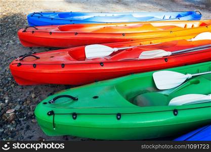 Closeup view of colorful canoe boats on the beach, ready for use. Sunny day